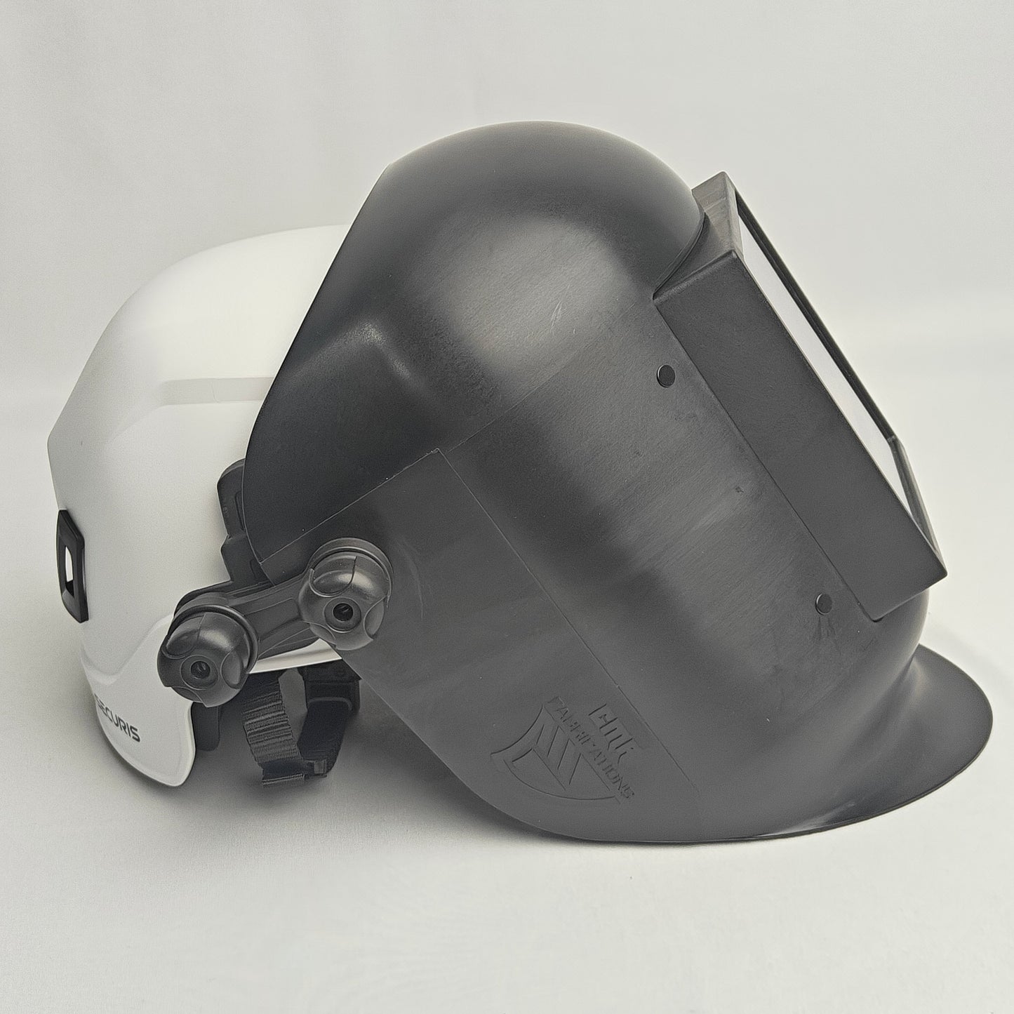 White hard hat with a gray welding helmet on a light gray background