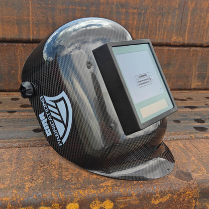 CMR Fabrications Carbon fiber Pipeliners Sugar scoop welding helmet with digital display on a rusty metal surface