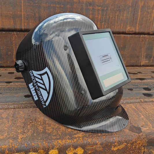 CMR Fabrications Carbon fiber Pipeliners Sugar scoop welding helmet with digital display on a rusty metal surface