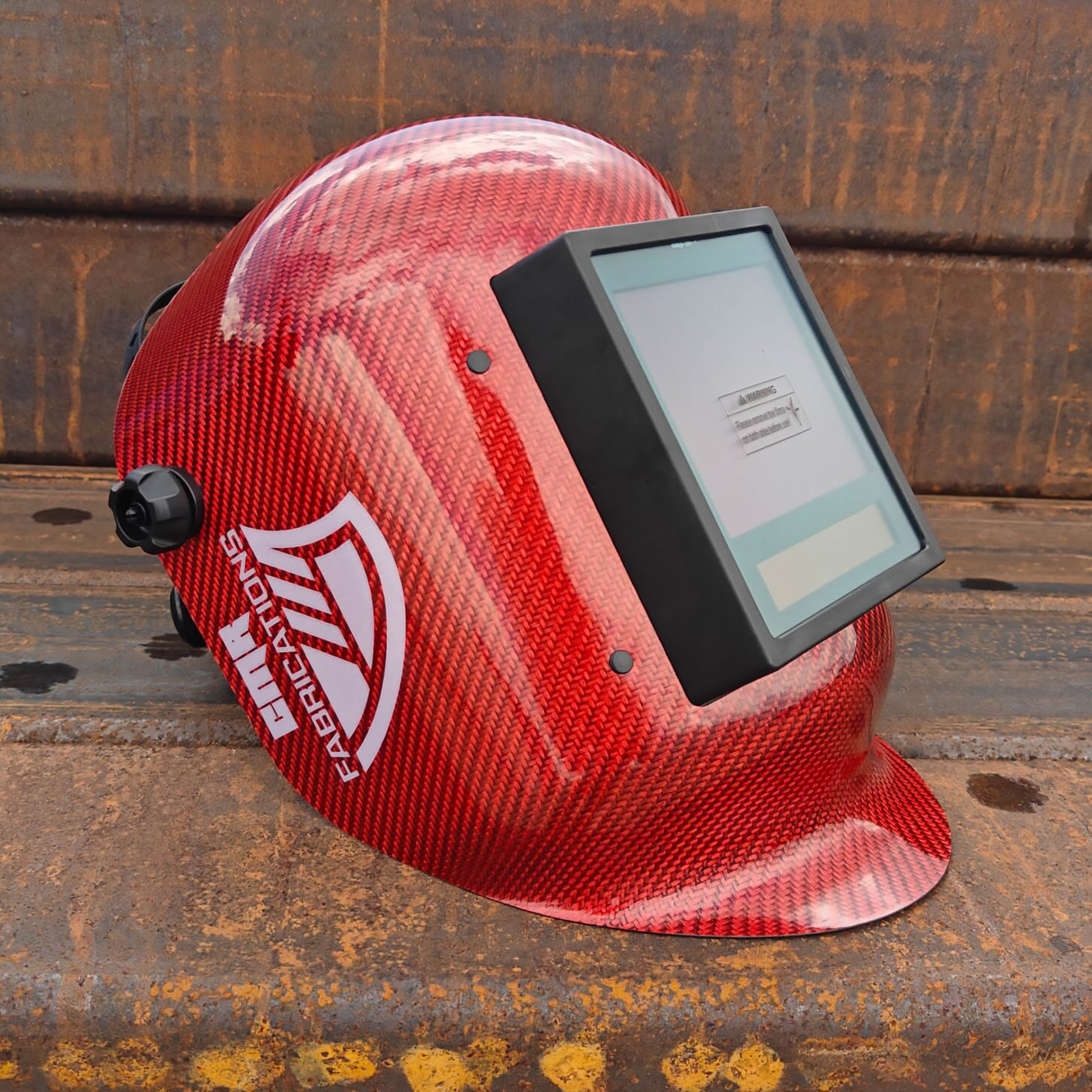 CMR Fabrications Carbon fiber Pipeliners Sugar scoop welding helmet Red with digital display on a rust surface.