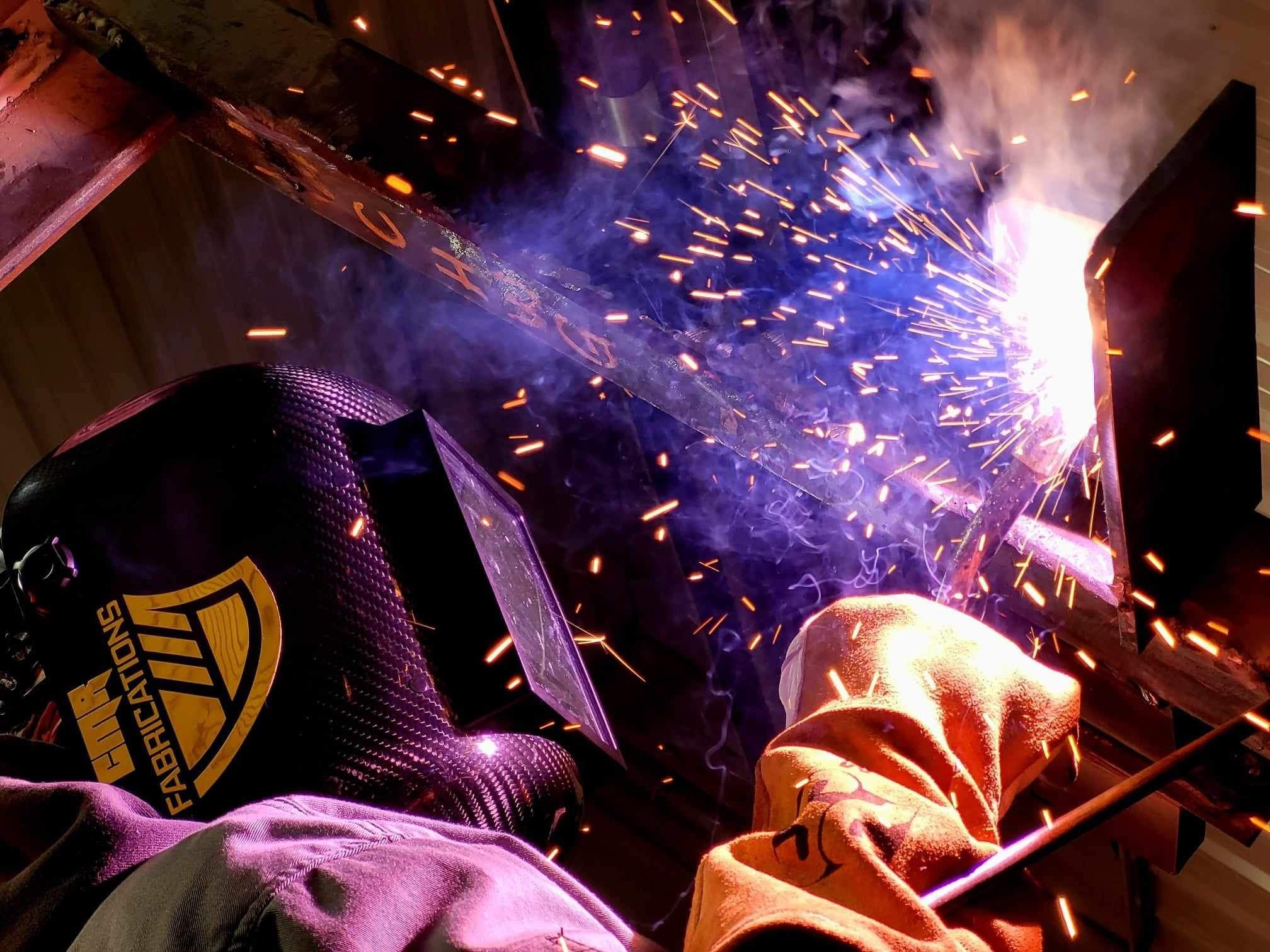 Person welding with sparks flying in a workshop setting wearing a CMR Fabrication Large view Pipeliner Sugar Scoop welding hood 
